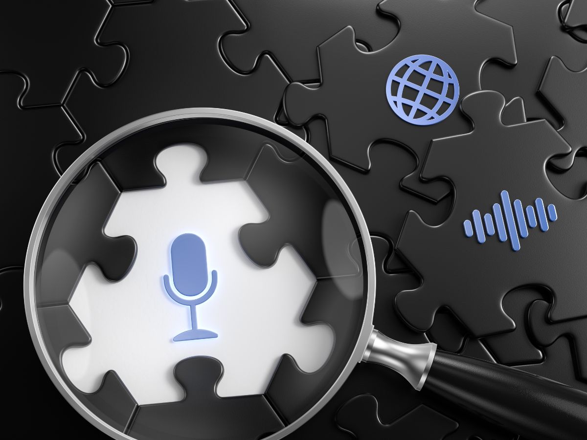 A magnifying glass over a puzzle piece with a microphone icon.