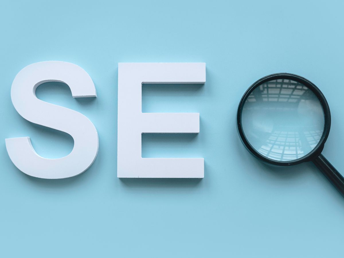 The letters "SEO" with a magnifying glass on a blue background, symbolizing search optimization.