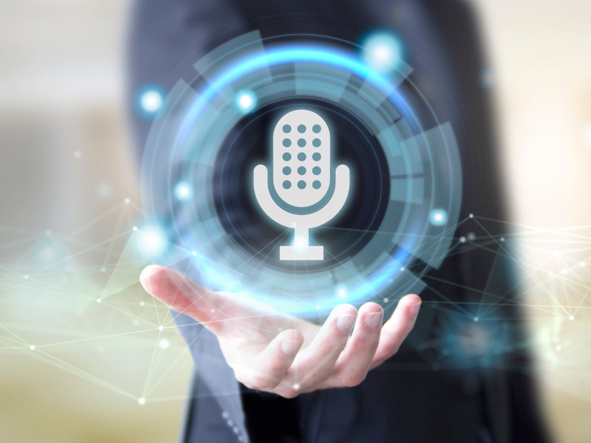 A futuristic microphone icon hovering over a businessman's hand.