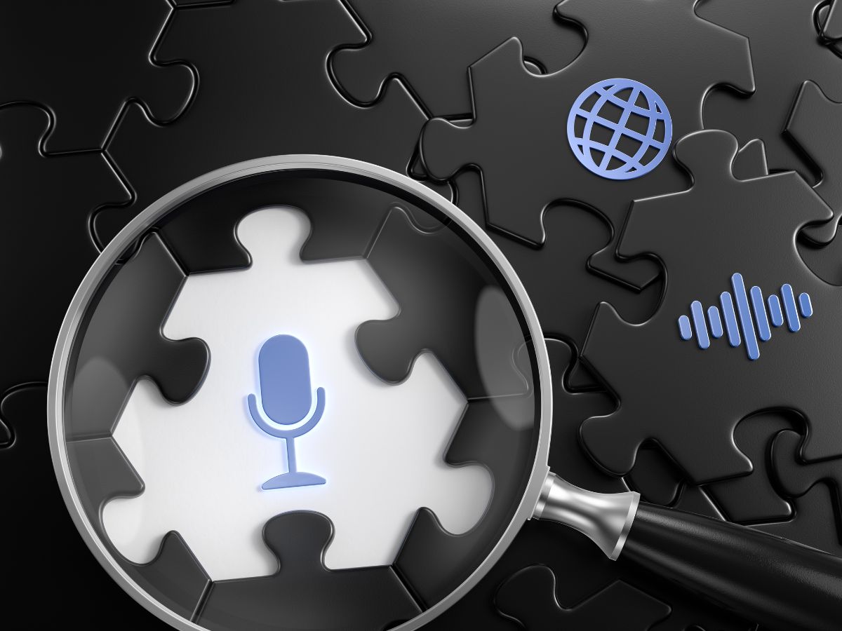 Magnifying glass over a puzzle piece with a microphone icon.